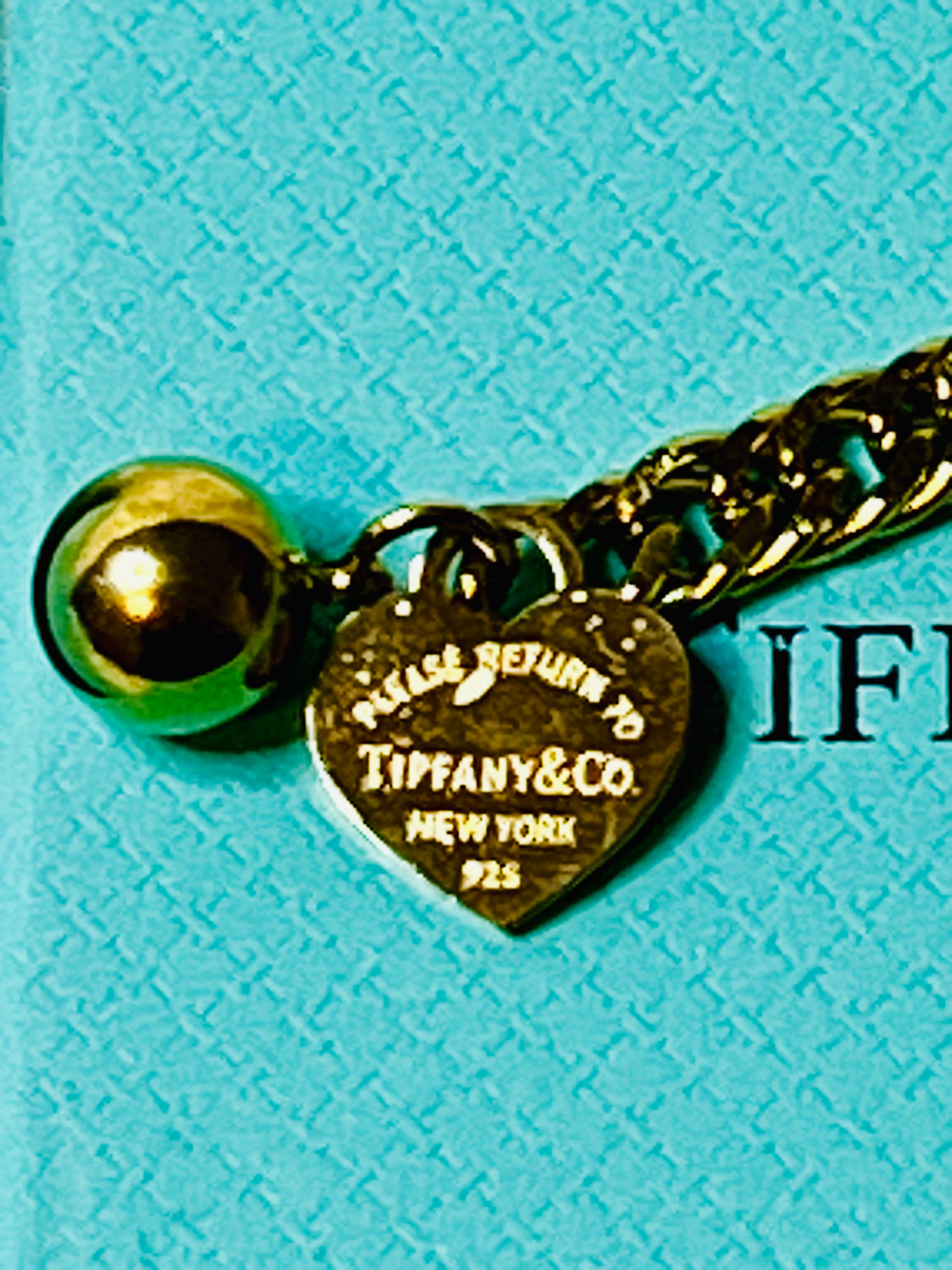 Tiffany & Co. Iconic Please Return to Tiffany Gold Woven Bracelet with Heart Shaped Blue & Gold Ball Dangle